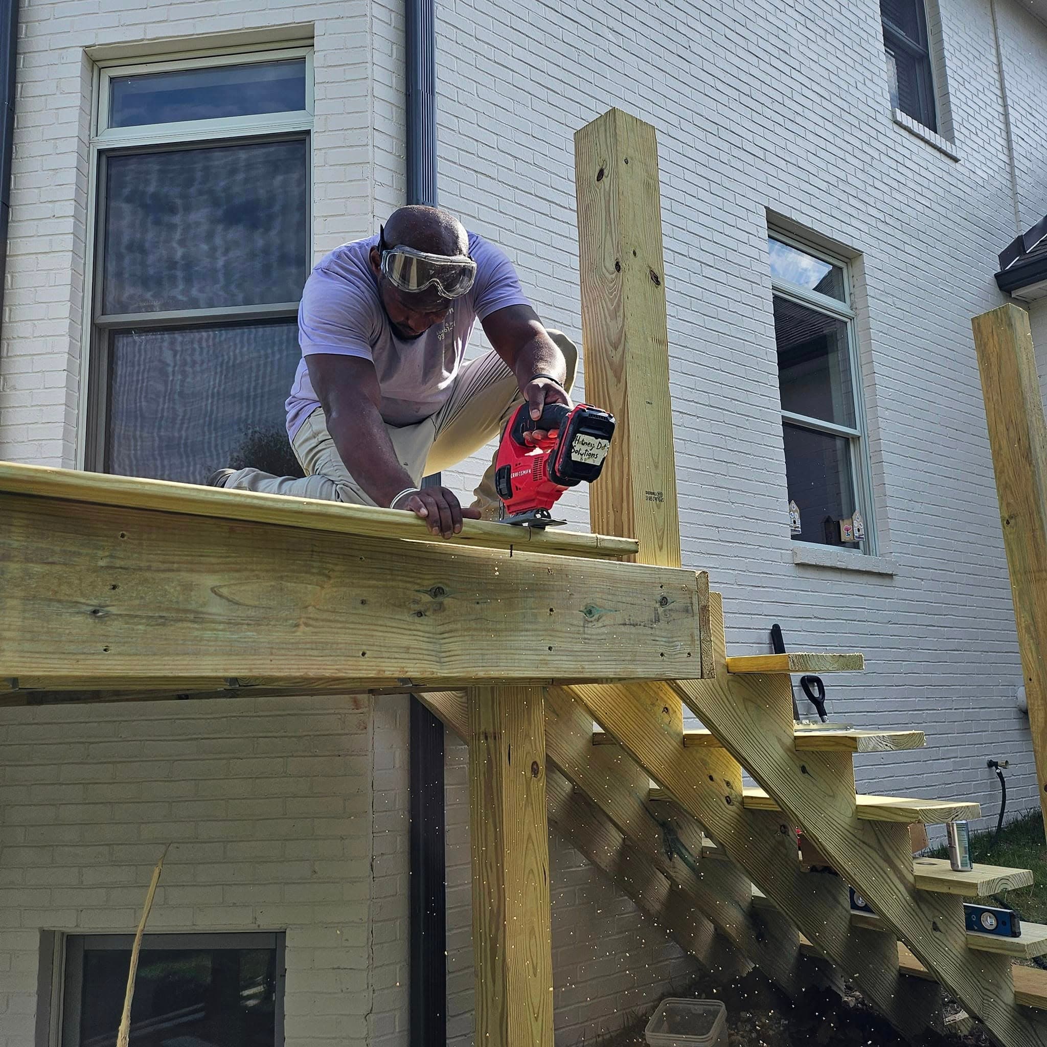 Dontey Gay cutting framing lumber on a Honey Do Solutions deck build
